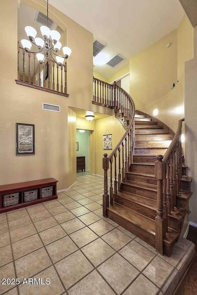 21840 N 43rd St, Phoenix, AZ 85050 - staircase with visible vents, a high ceiling, tile patterned flooring, and an inviting chandelier
