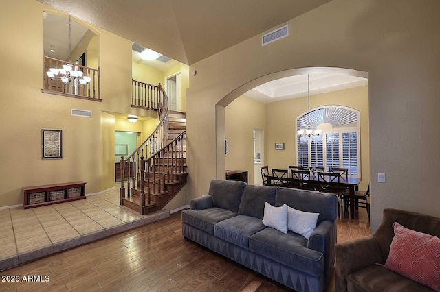 21840 N 43rd St, Phoenix, AZ 85050 - living area with stairs, a chandelier, wood finished floors, visible vents, and arched walkways