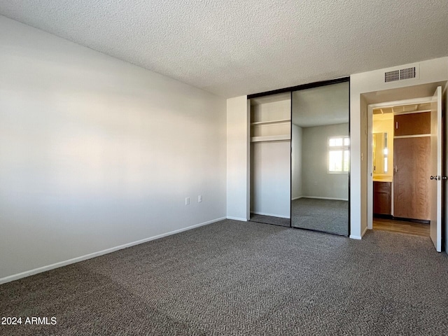 unfurnished bedroom with a textured ceiling and a closet