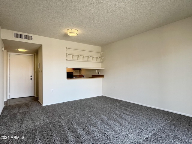 carpeted empty room featuring a textured ceiling