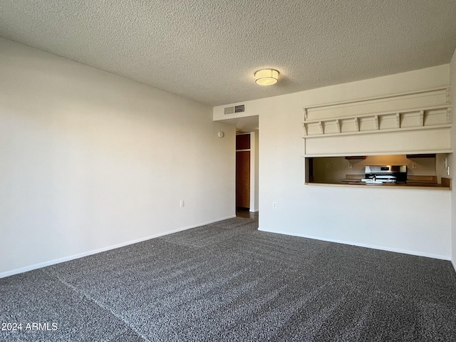 unfurnished living room featuring dark carpet and a textured ceiling