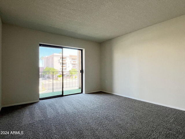 carpeted spare room with a textured ceiling