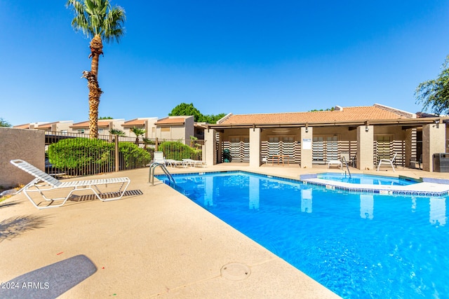 view of pool featuring central AC unit, a community hot tub, and a patio area