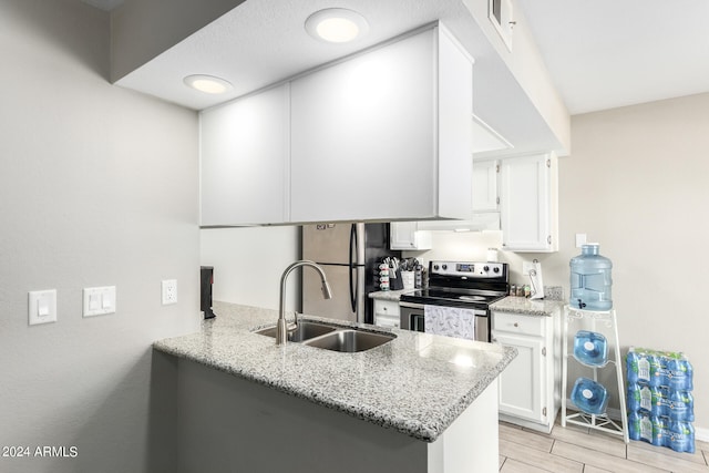 kitchen featuring sink, kitchen peninsula, stainless steel appliances, and white cabinetry