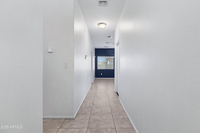 hall with visible vents, baseboards, and light tile patterned floors