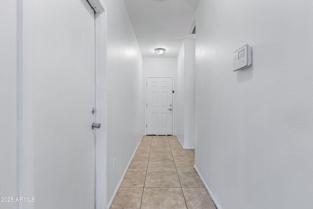 hallway with baseboards and light tile patterned floors