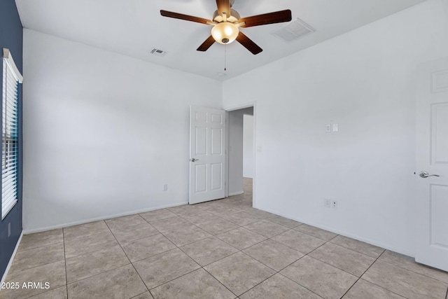 empty room with light tile patterned floors, visible vents, and a ceiling fan