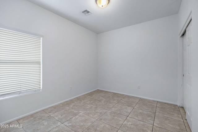 spare room featuring visible vents, baseboards, and light tile patterned floors