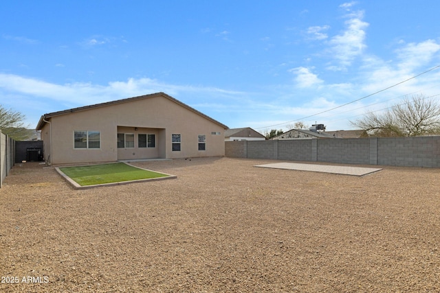 rear view of house featuring a fenced backyard, a patio, and stucco siding