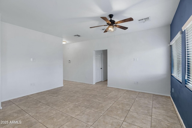 spare room featuring baseboards, light tile patterned flooring, visible vents, and a ceiling fan