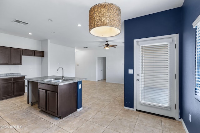 kitchen featuring ceiling fan, light tile patterned floors, a sink, visible vents, and dark brown cabinets