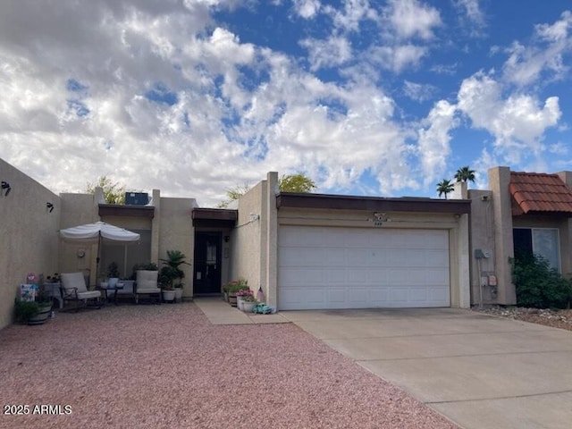 view of front facade featuring a garage, driveway, and stucco siding