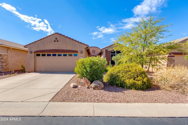 view of front of property featuring a garage, concrete driveway, a tiled roof, and stucco siding