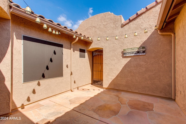 view of exterior entry featuring a patio