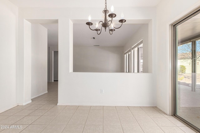 tiled empty room with an inviting chandelier