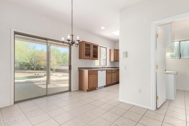 kitchen featuring white dishwasher, sink, hanging light fixtures, light tile patterned floors, and a notable chandelier