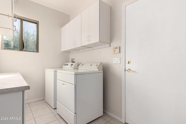 laundry area featuring cabinets, independent washer and dryer, and light tile patterned floors