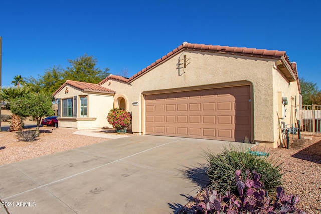 mediterranean / spanish home featuring a garage