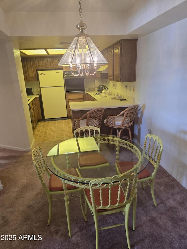 dining area featuring baseboards, light colored carpet, and an inviting chandelier