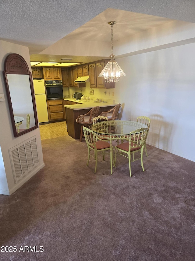 dining area with visible vents, a textured ceiling, a chandelier, and carpet flooring