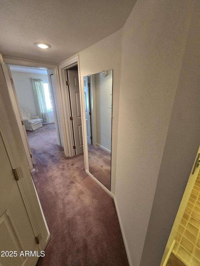 hall with baseboards and carpet floors