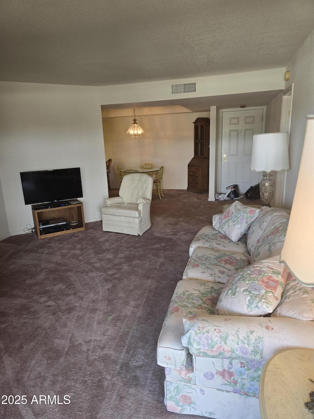 living area featuring visible vents, a textured ceiling, and carpet floors