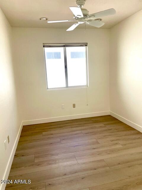 unfurnished room with ceiling fan and light hardwood / wood-style flooring