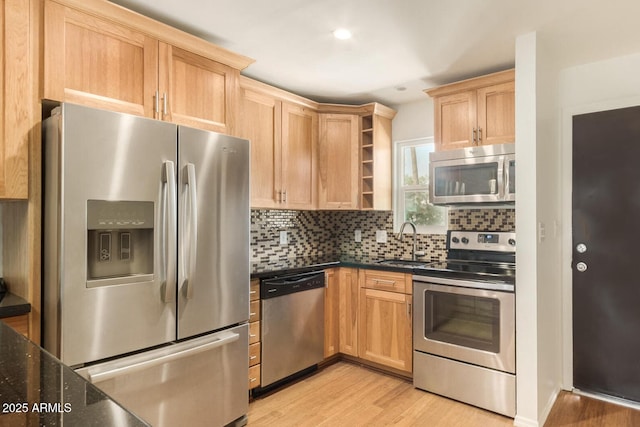 kitchen with sink, light hardwood / wood-style flooring, light brown cabinets, stainless steel appliances, and decorative backsplash