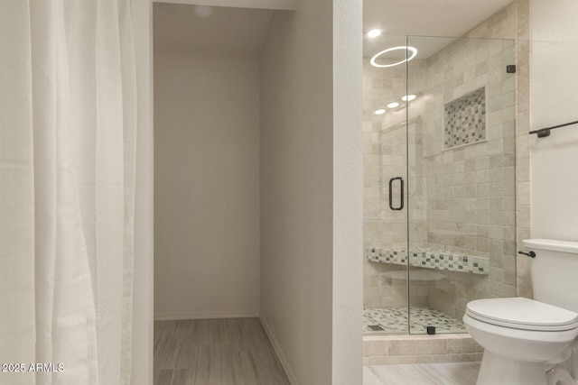 bathroom featuring an enclosed shower and toilet