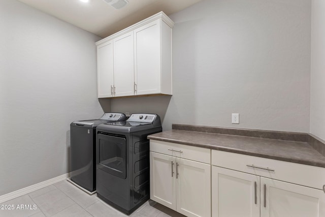 laundry area with separate washer and dryer, cabinets, and light tile patterned flooring