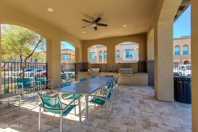 view of patio with exterior kitchen, a grill, and ceiling fan