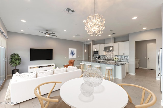 dining space with ceiling fan with notable chandelier