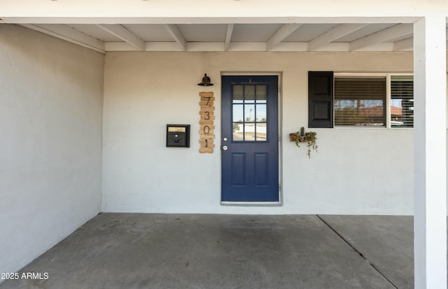 view of exterior entry featuring covered porch