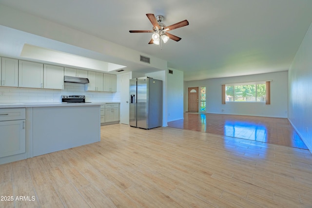 1726 W Claremont St, Phoenix, AZ 85015 - kitchen with appliances with stainless steel finishes, under cabinet range hood, open floor plan, ceiling fan, and light wood finished floors