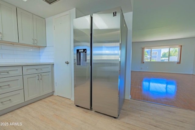 1726 W Claremont St, Phoenix, AZ 85015 - kitchen featuring stainless steel fridge, light wood-style flooring, decorative backsplash, and light countertops