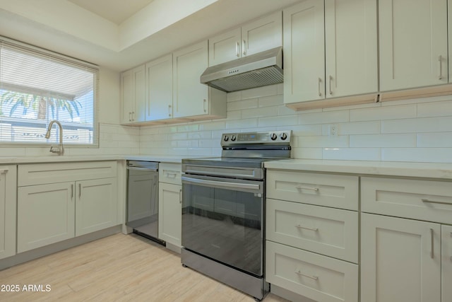 1726 W Claremont St, Phoenix, AZ 85015 - kitchen with under cabinet range hood, stainless steel appliances, a sink, light countertops, and tasteful backsplash