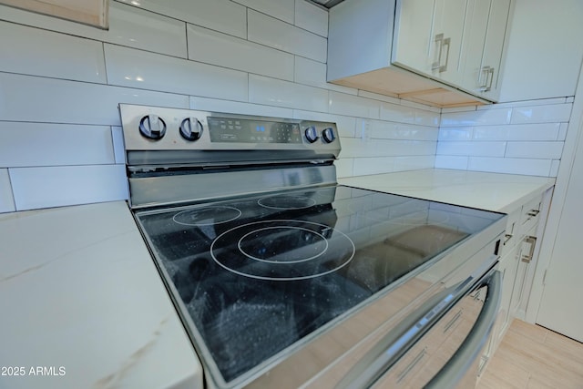 1726 W Claremont St, Phoenix, AZ 85015 - kitchen view of stainless steel electric stove, tasteful backsplash, and light countertops