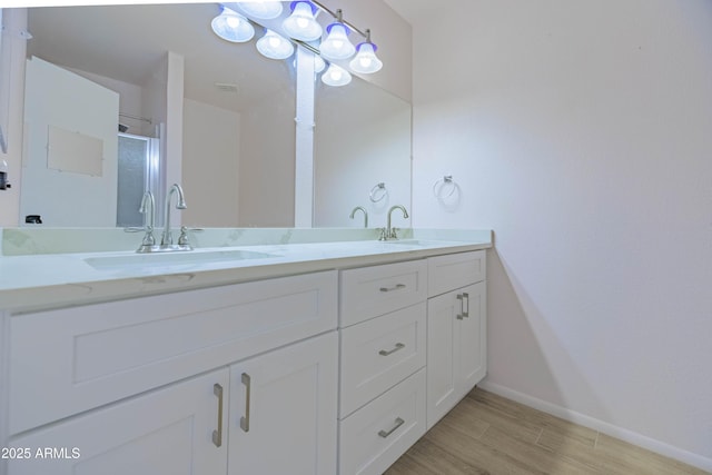 1726 W Claremont St, Phoenix, AZ 85015 - full bathroom with double vanity, baseboards, a shower stall, and wood finished floors