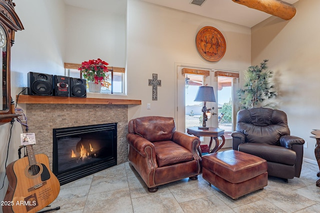 living room featuring a tile fireplace and beam ceiling