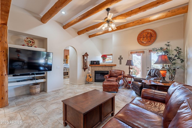 living room with beam ceiling, ceiling fan, and french doors