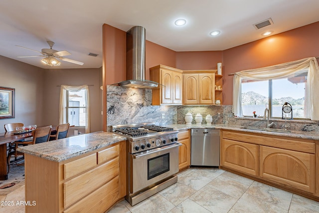 kitchen featuring appliances with stainless steel finishes, wall chimney exhaust hood, light brown cabinets, sink, and backsplash