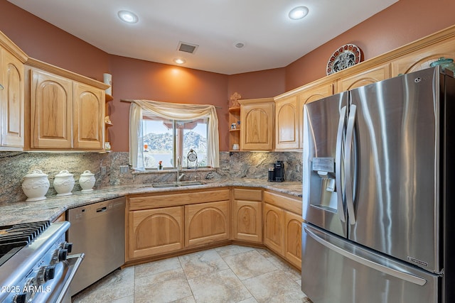 kitchen with stainless steel appliances, light brown cabinetry, tasteful backsplash, and sink