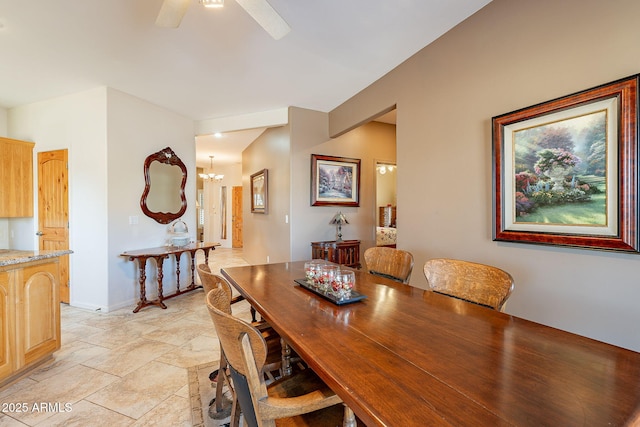 dining space with ceiling fan with notable chandelier