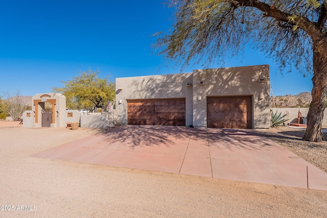 pueblo-style house featuring a garage