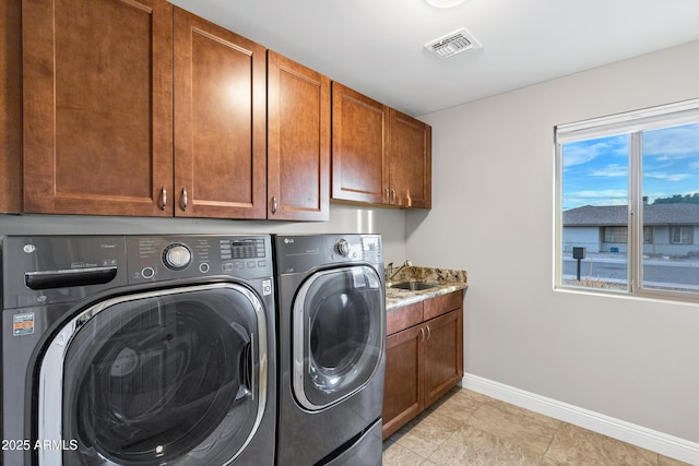 laundry area with cabinets, washing machine and clothes dryer, and sink