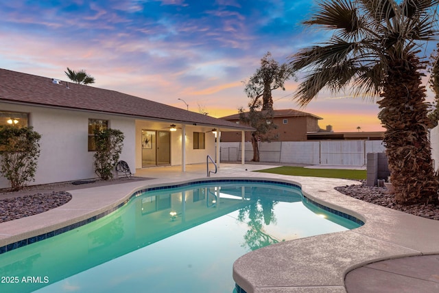 pool at dusk with a patio