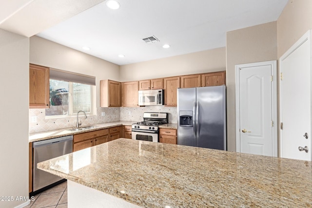 kitchen featuring tasteful backsplash, visible vents, appliances with stainless steel finishes, light stone counters, and light tile patterned flooring