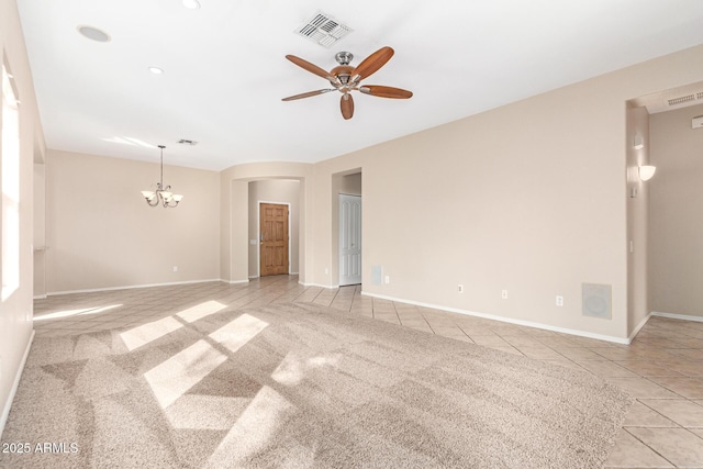 unfurnished room featuring light carpet, ceiling fan with notable chandelier, visible vents, and light tile patterned flooring