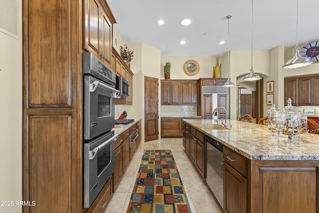 kitchen featuring a sink, stainless steel appliances, decorative backsplash, recessed lighting, and a large island with sink