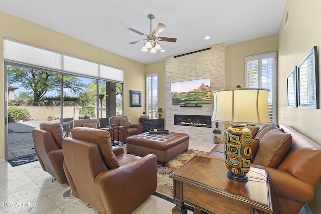 living area featuring a ceiling fan, plenty of natural light, a fireplace, and recessed lighting